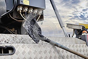 Construction tool for road works. Shovel for laying asphalt close-up lies on the asvalt laying machine. Asphalting of roads