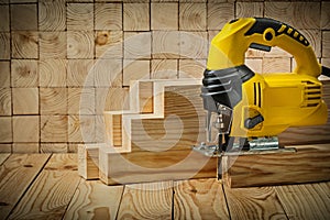 Construction tools  in real conditions yellow corded jigsaw stay on wooden beam