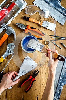 Construction tools on a wooden table with blue paint