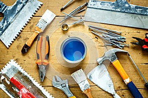 Construction tools on a wooden table with blue paint