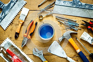 Construction tools on a wooden table with blue paint
