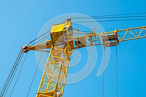 Construction tower crane against the background of the blue sky skyline close