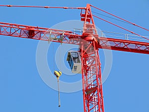 Construction tower crane detail in bright red color. steel truss structure and hoist.