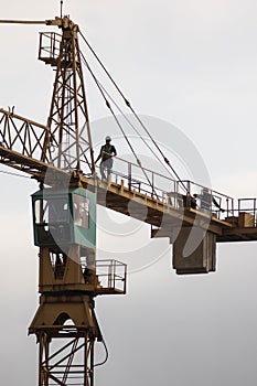 Construction tower crane with worker in top showing height of the crane