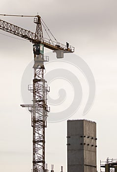 Construction tower crane with worker in top showing height of the crane