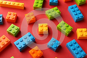 Construction toy. Colorful building bricks on red background, closeup