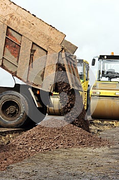 Construction truck unloads ground to the construction site and road widening