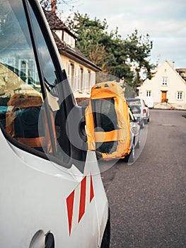 Construction van with broken rear view mirror glued with orange worker scotch