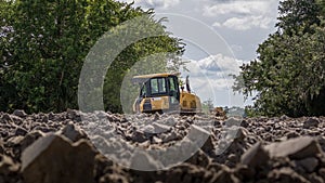 Construction Vehicle - Front Loader.  Loader sits in the dirt on a construction site in the woods