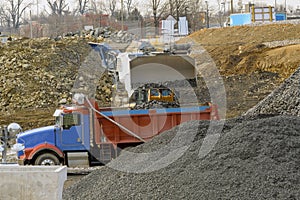 a construction vehicle loading gravel into a huge dump truck