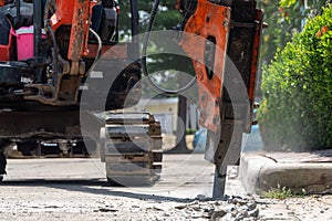 Construction Vehicles repairing road. drilled into the driveway surface with jackhammer