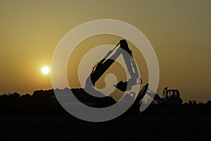 Construction vehicles in the sunset