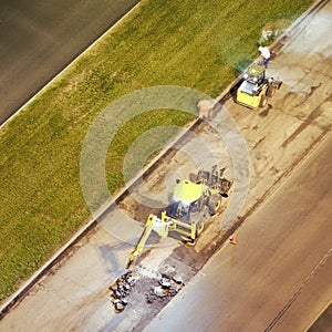 Construction vehicles and workers repairing the night road