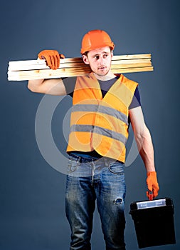 Construction and woodworking concept. Carpenter, woodworker, labourer, builder on dreamy face carries wooden beams on
