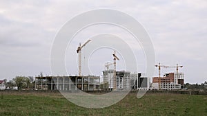 Construction work on new building of residential complex. Construction site. Building cranes, residential apartment houses under c