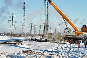 Construction work on pipe laying of pipeline into the trench using a crane
