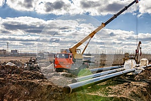 Construction work on pipe laying of pipeline into the trench using a crane
