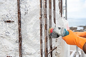 Construction worker with angle grinder polishing rods