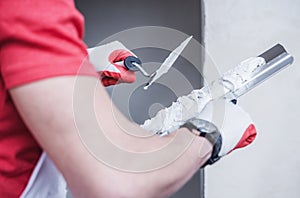 Construction Worker Applying Drywall Compound On Taping Knife