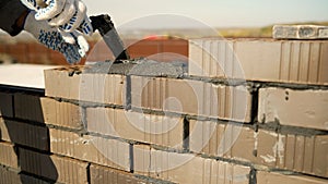 Construction worker building a wall with bricks and mortar