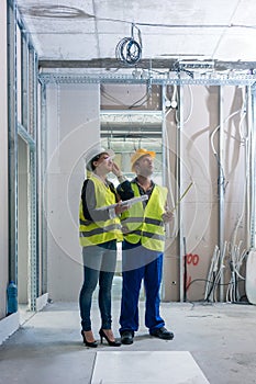 Construction worker and architect discussing work to be done at site