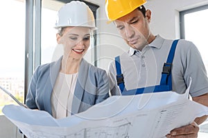 Construction worker and architect looking at plan on site