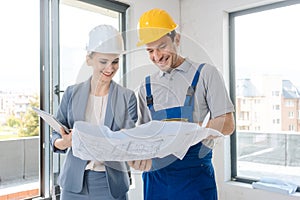 Construction worker and architect looking at plan on site