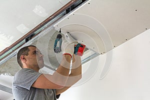 Construction worker assemble a suspended ceiling with drywall an