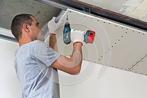 Construction worker assemble a suspended ceiling with drywall an