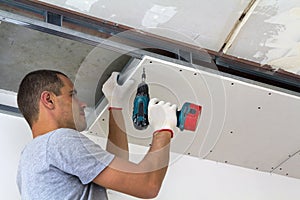 Construction worker assemble a suspended ceiling with drywall an