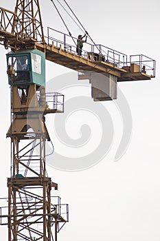 Construction worker attends to maintenance on a tower crane