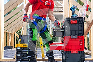 Construction Worker and Big Pile of His Tools and Equipment