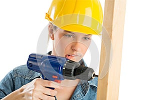 Construction Worker Biting Lip While Drilling Wooden Plank