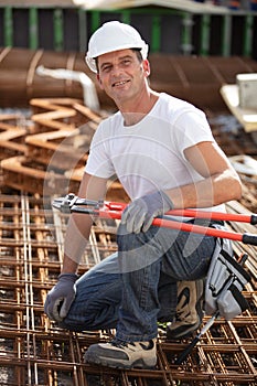 construction worker with bolt croppers on reinforcement bars