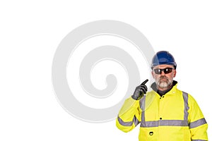 A construction worker in a bright yellow hi-viz coat and safety gloves wearing tinted safety glasses for eye protection isolated