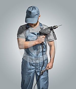 Construction worker builder with drill and wrench on the isolated background