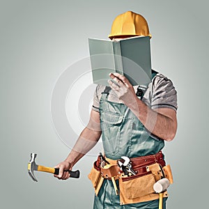 Construction worker, builder with a tool belt and book