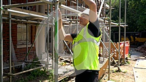 Construction worker on building site inspecting and checking scaffolding