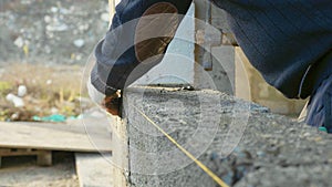 Construction worker builds brick wall, closeup view at construction site