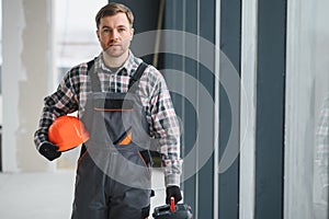 Construction worker carrying tools and helmet in building