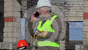 Construction worker with cell phone, trowel and mallet