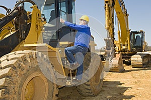 Construction Worker Climbing Heavy Equipment photo