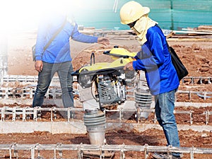 Construction worker compacting soil