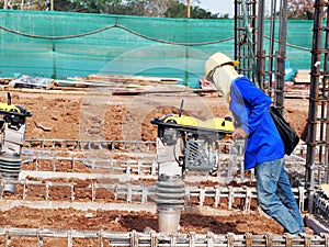Construction worker compacting soil