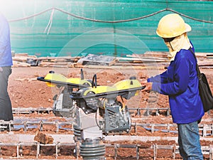 Construction worker compacting soil