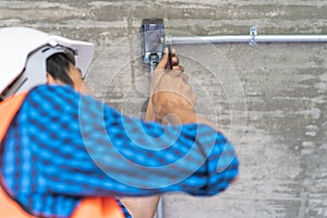 Construction worker and contractor. Electrician prepare to wire electric system on the ceiling in reconstruction room