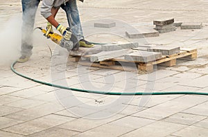 Construction worker cuts walkway curb with circular saw. Man Protect Hearing From Noise Hazards on the Job