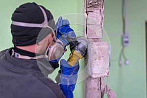 Construction worker cutting concrete wall by using electric cutter