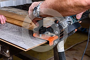 Construction worker cutting laminate using angle grinder with stand for 45 degree.