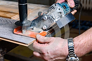 Construction worker cutting laminate using angle grinder with stand for 45 degree.